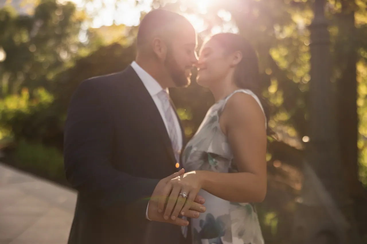 Kevin and Sarina about to kiss, backlit by the golden evening sun