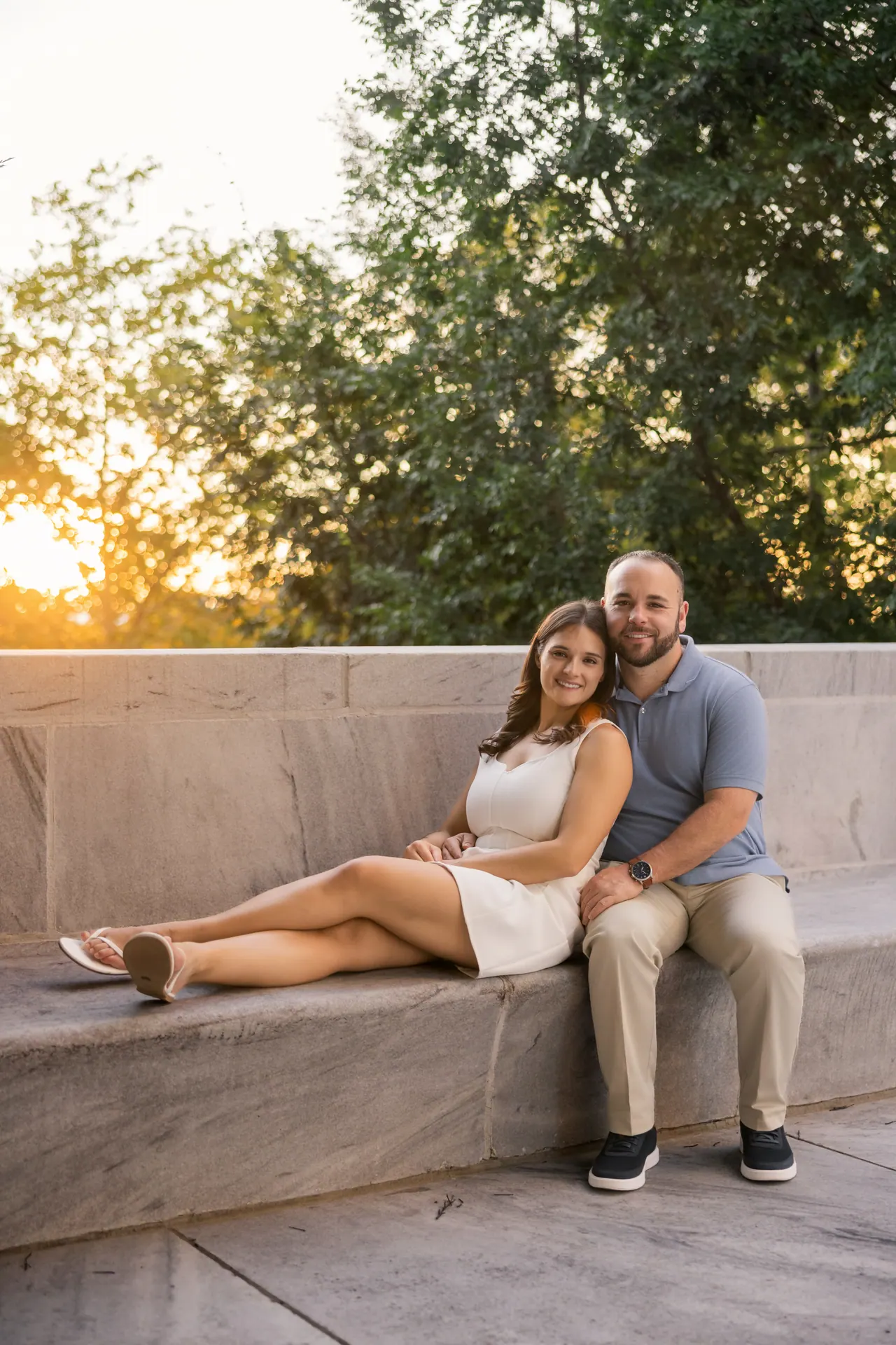 Kevin and Sarina lounging on a stone ledge at sunset