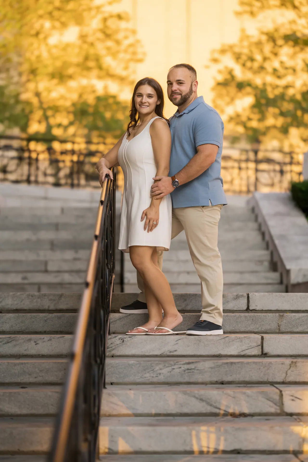 Kevin and Sarina on wide stone steps glowing in the sunset